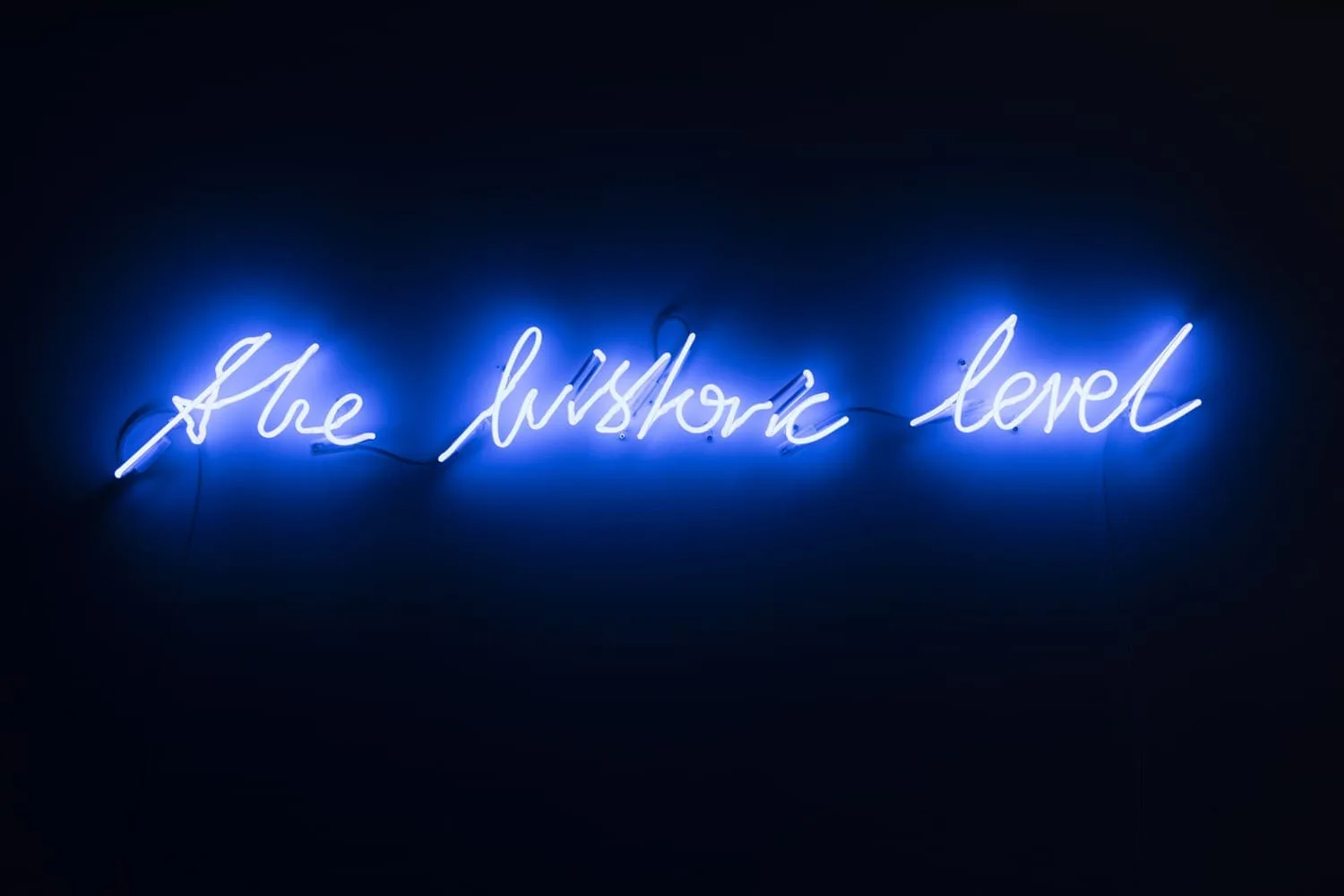 Michal Martychowiec, the historic level, 2017: blue neon lettering “the historic level” in the dark