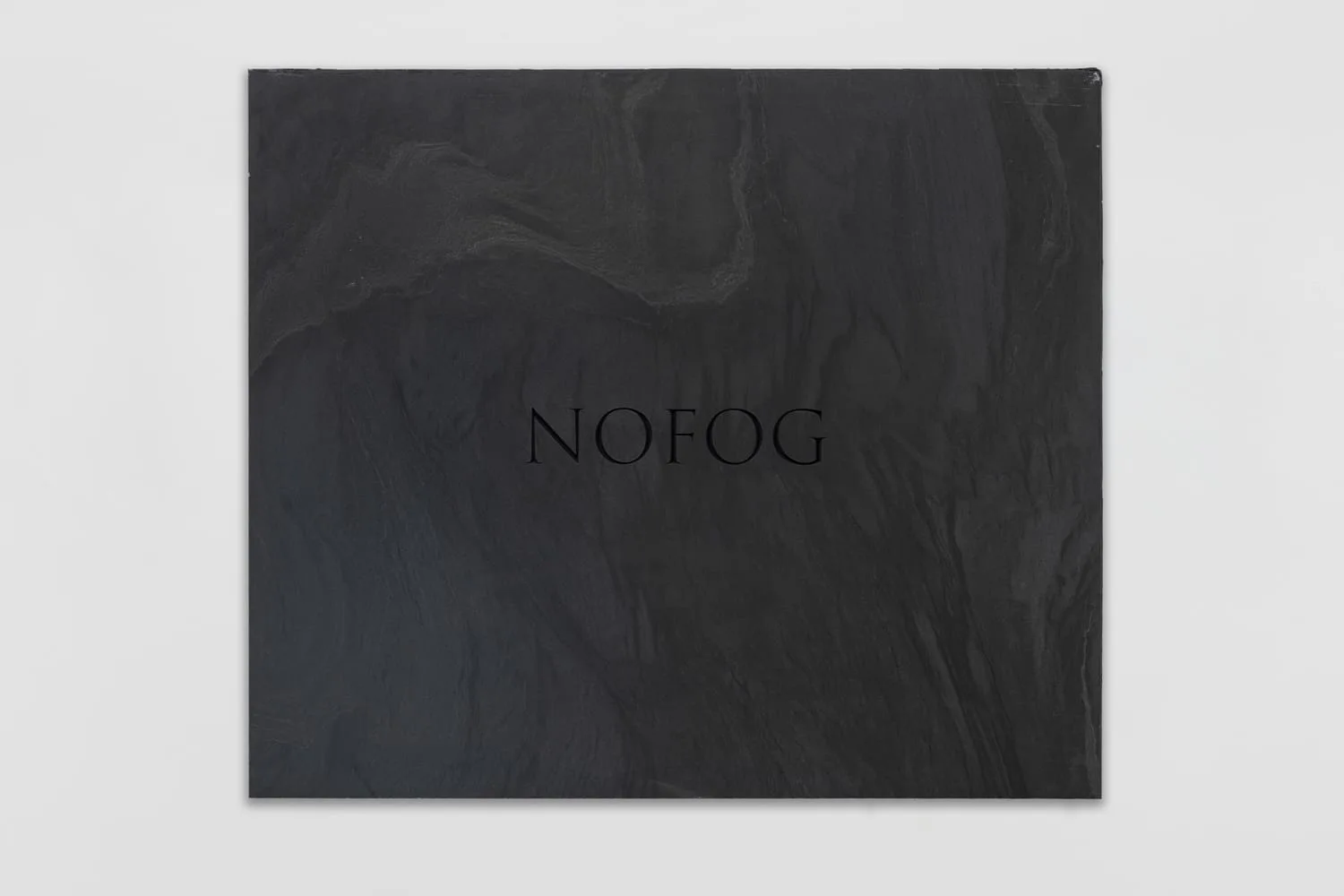 JMH Schindele, NOFOG, 2026: black marble slab (Monte Nero) with the engraving “NOFOG” in ultra-black, 90 × 85 × 2 cm