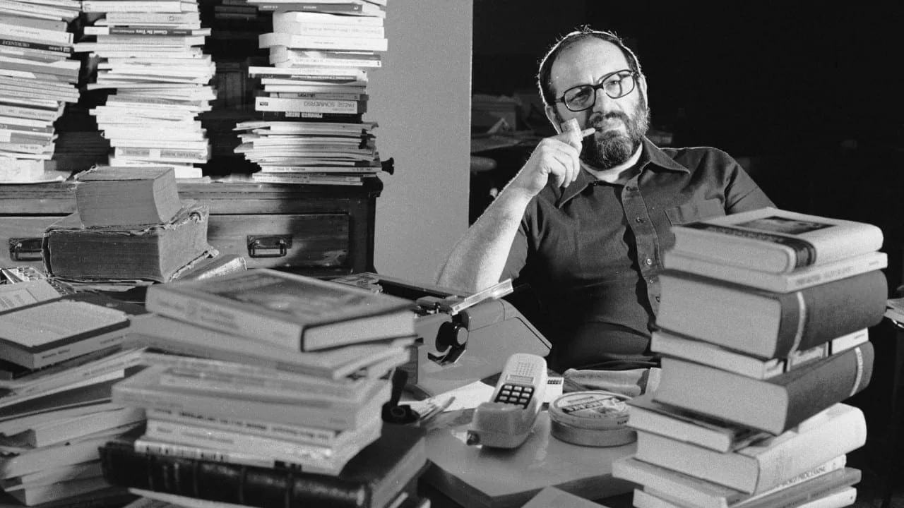 Umberto Eco 1977, an einem Schreibtisch zwischen Bücherstapeln, Schwarz-Weiß