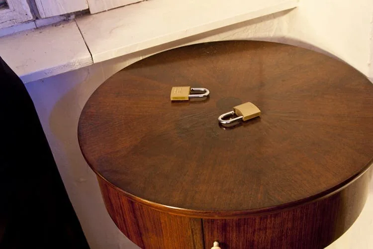 Round wooden drum with two padlocks on top in warm light