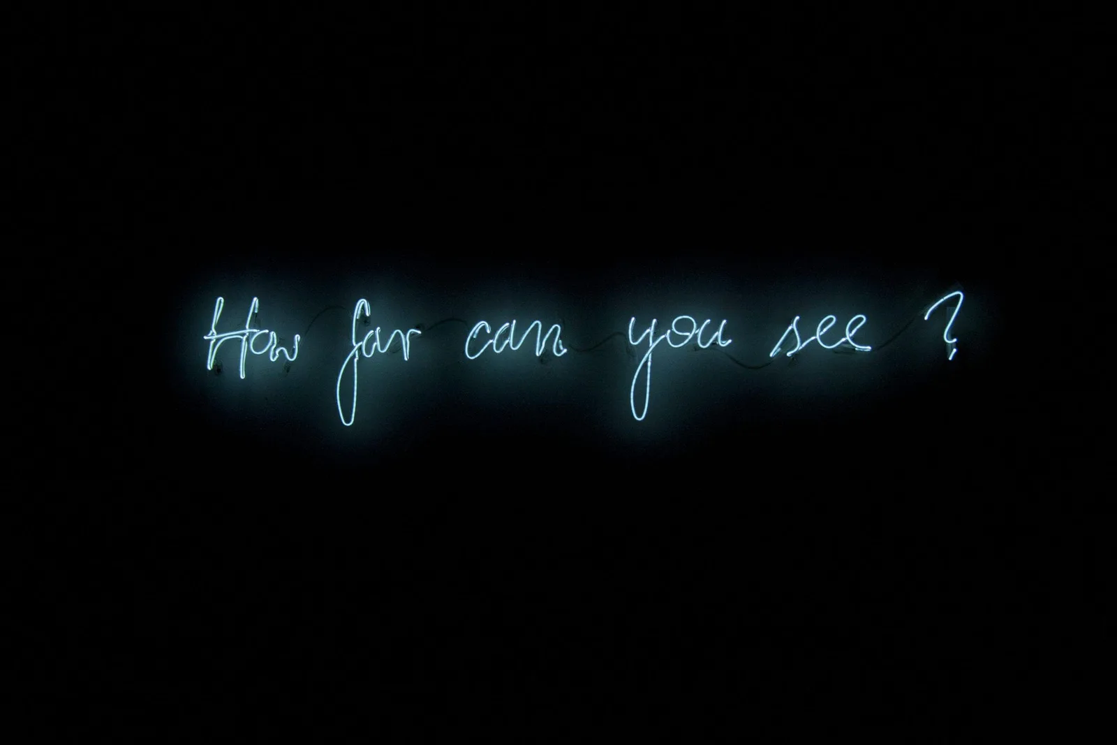 Michal Martychowiec, How far can you see?, 2013: weiße Neonschrift „How far can you see?“ in der Dunkelheit