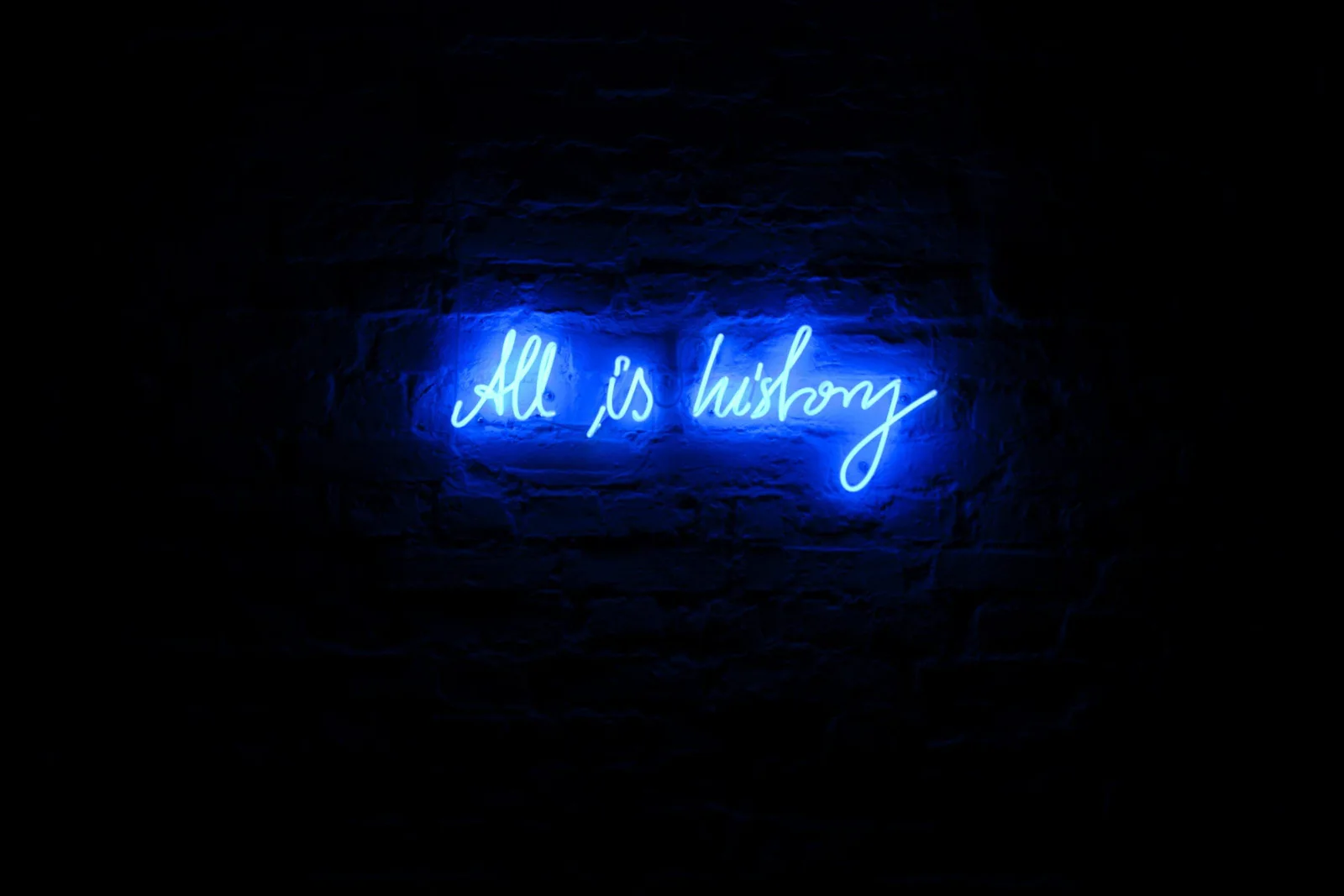 Michal Martychowiec – All is history, 2012: blaue Neonschrift „All is history“ an einer dunklen Wand