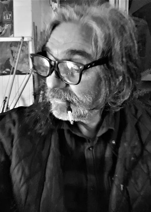 Portrait of Hilarion Manero wearing glasses in his studio, black and white