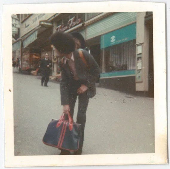 El Arbi Bouqdib mit Reisetasche auf einer Einkaufsstraße in den 70ern, altes Farbfoto