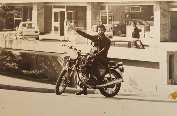 El Arbi Bouqdib auf einem Motorrad vor einem Gebäude, altes Schwarz-Weiß-Foto
