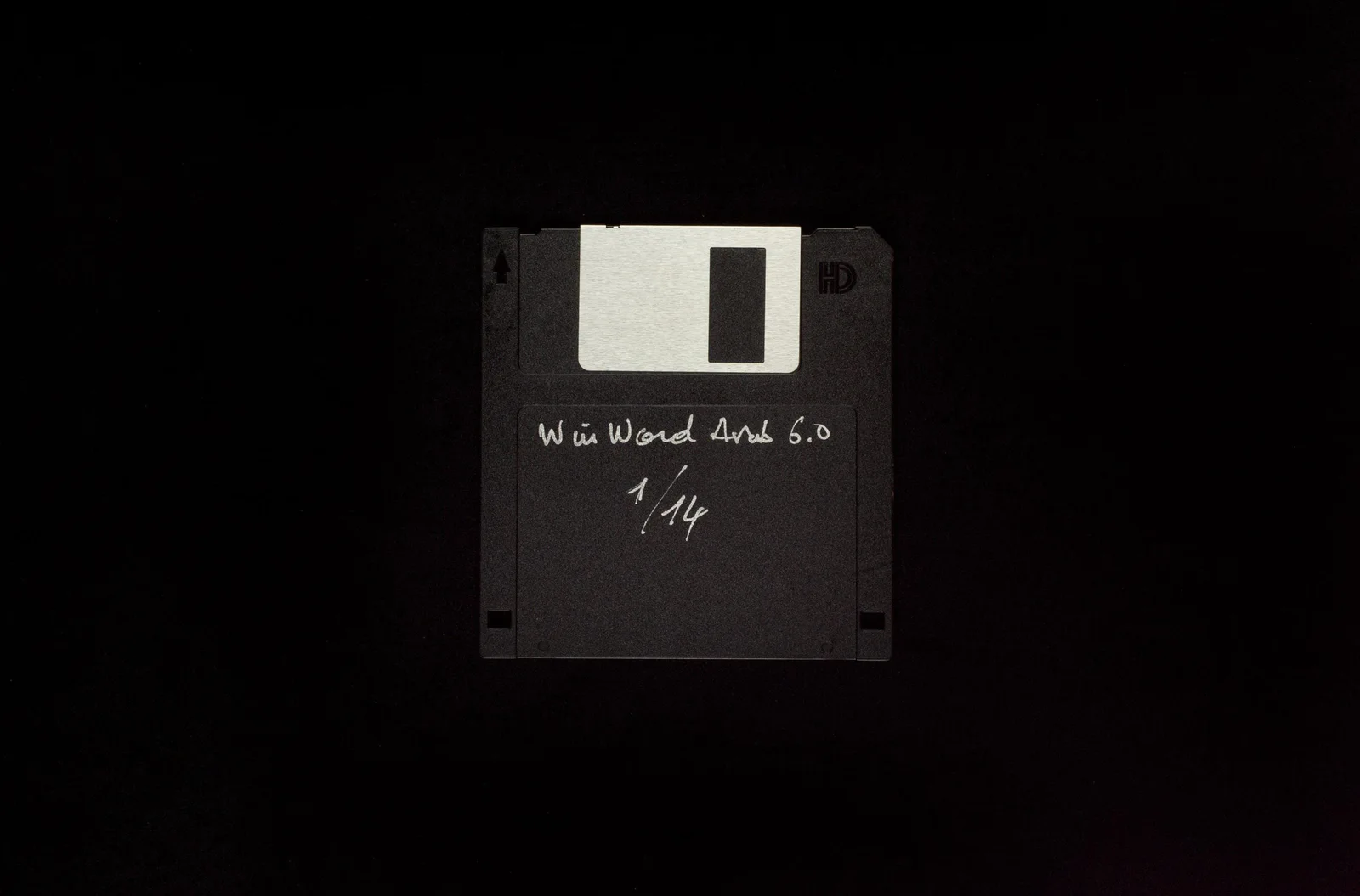 2-1 WIN WORD ARAB 6.0 (unbekannt): eine 3,5-Zoll-Diskette mit handschriftlicher Beschriftung vor schwarzem Hintergrund