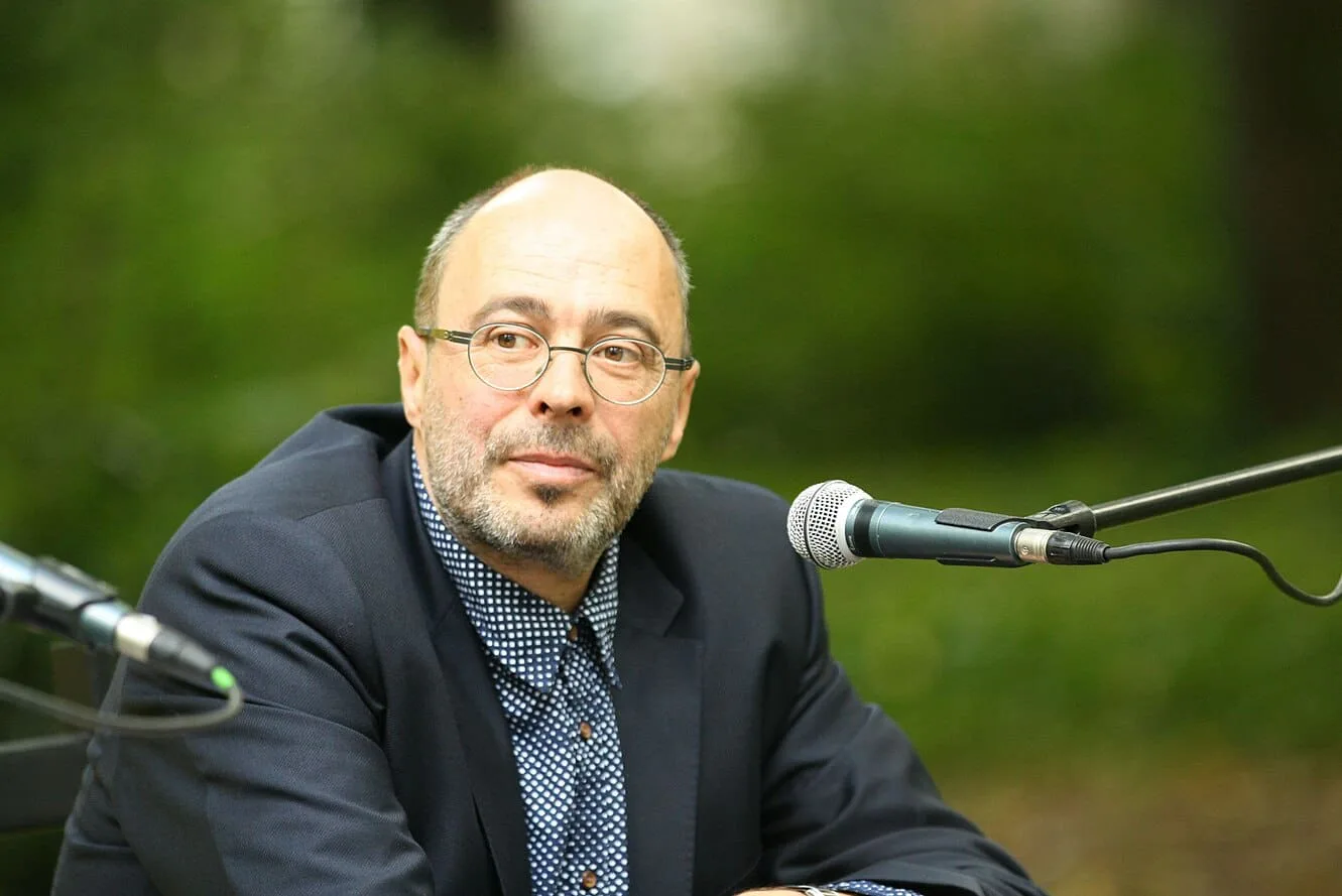 Michael Kleeberg mit Brille am Mikrofon vor grünem Hintergrund, Foto Amrei-Marie
