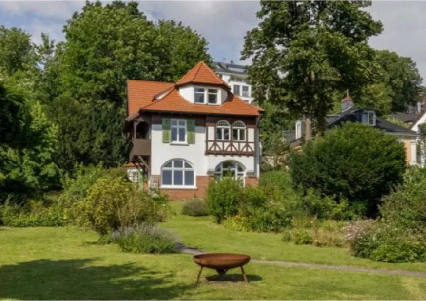 Wohn- und Projekthaus Övelgönne 106: Villa mit rotem Dach und Fachwerk in einem Garten, Foto Hausfotografie.de