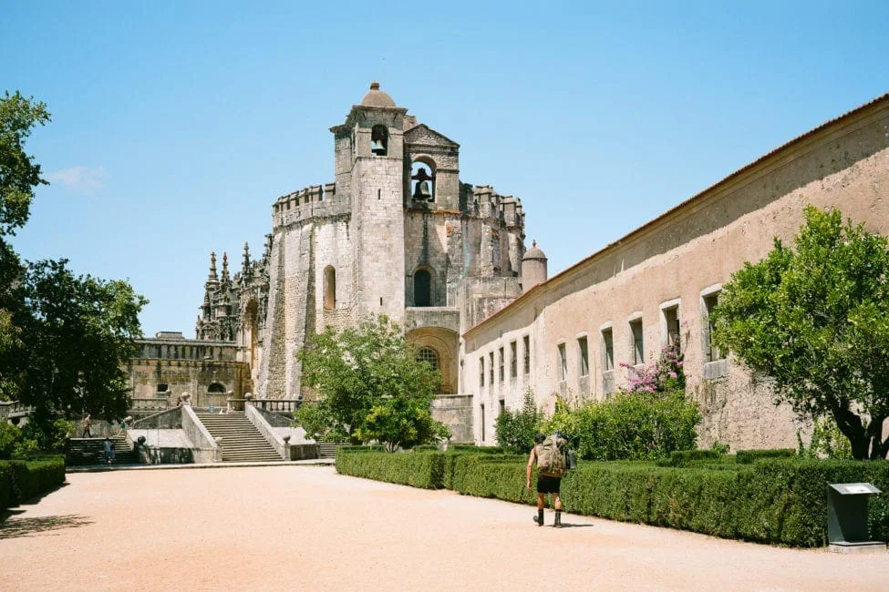 GABRIEL: a man walking past the round church and buildings of the Convent of Christ in Tomar
