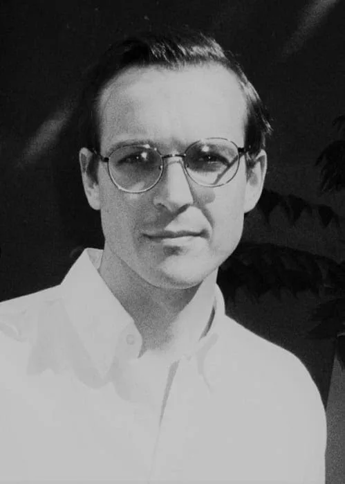 Portrait of Julian M. H. Schindele wearing glasses and a white shirt, black and white, photo Stefan Hähnel