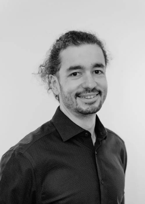 Portrait of Joseph Bouqdib, smiling, black and white