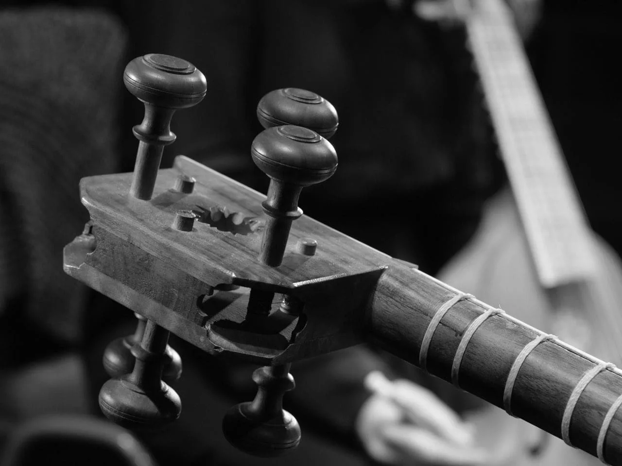 Close-up of the tuning pegs of a tar being played, black and white, photo Folkert Uhde